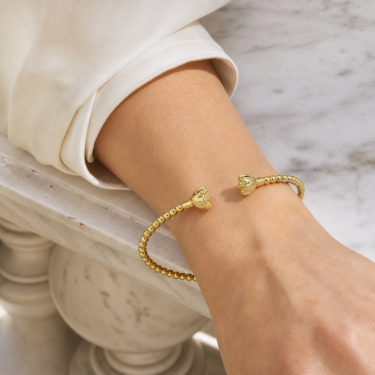 A gold bracelet worn at the wrist
